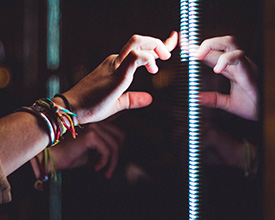 Person wearing silver bracelet holding a light