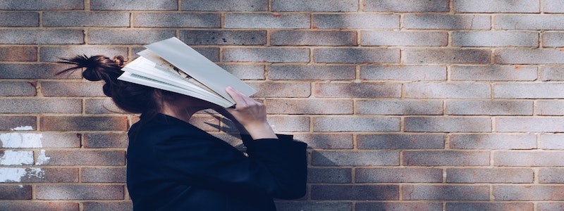 Girl hiding her face with a book